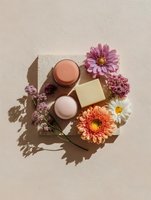 Natural cosmetic products arranged on concrete platform with fresh flowers, creating elegant spa composition with soft shadows on beige background.