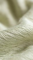 Close-up macro shot of natural beige rope fibers with soft focus background, showing detailed texture and weaving pattern for nautical and craft projects.