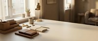 Minimalist wooden desk setup with notebooks, coffee cup and warm sunlight streaming through window creating cozy home office workspace atmosphere.