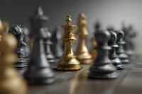 Golden chess king standing out among black and white pieces on wooden board, symbolizing leadership, strategy and competitive advantage.