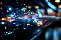 Finger pointing at glowing digital data visualization with colorful bokeh lights and programming code elements in dark modern office environment.
