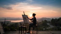 Silhouette of female artist painting on easel at sunset overlooking misty valley and river landscape, creative outdoor workspace.