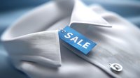 White formal shirt with blue sale tag attached to collar, showcasing retail discount promotion for menswear or business attire.
