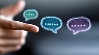 Glowing digital chat bubbles floating above pointing hand, illustrating online communication and social media messaging concept on dark background.