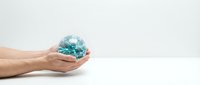 Hands holding glowing turquoise globe on white background, symbolizing global responsibility, environmental care, and sustainable business practices for corporate and eco-friendly designs.