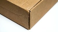 Brown corrugated cardboard shipping box corner detail showing textured surface and folded edges for packaging and delivery applications.