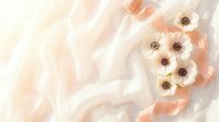 Delicate white anemone flowers with peach ribbon on soft flowing fabric, elegant floral flat lay in pastel tones for wedding or beauty design.
