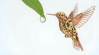 Ornate wooden hummingbird with intricate laser-cut patterns and detailed wings on white background, perfect for nature-inspired home decor projects.