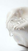 Milk splashing in cup with water droplets on white background, suitable for beverage, dairy, and food photography projects.