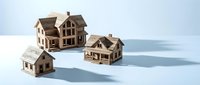 Wooden miniature house models arranged on a light blue surface, casting soft shadows, symbolizing real estate growth and property investment concepts.
