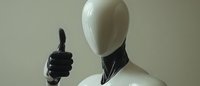 Mannequin wearing black gloves giving thumbs up gesture against neutral background, suitable for retail, fashion, approval, and success concepts.