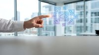 Business professional pointing at floating digital cloud computing icons in modern office environment with technology integration concepts.