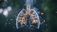 Glowing translucent human lungs with golden bronchial tree structure against dark background with bokeh light effects and smoke particles.