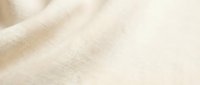 Beige linen fabric with soft diagonal folds and natural texture, suitable for textile, fashion, and interior design projects.