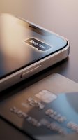 Smartphone with Shop Now button notification next to a credit card on dark surface, mobile payment and online shopping concept.