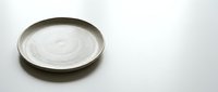 Empty ceramic plate with natural glaze finish on white background, minimalist tableware for food presentation and culinary photography projects.