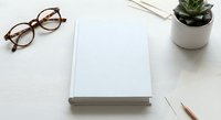 Blank white notebook with eyeglasses and succulent plant on clean desk workspace for writing, planning, and creative projects.