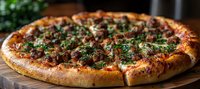 Fresh baked pizza with seasoned ground beef, melted cheese and chopped herbs on golden brown crust, served on wooden cutting board. Close up food photography.