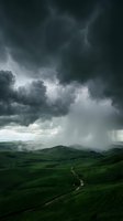 Dramatic storm clouds gathering over rolling green hills with winding road, moody atmospheric landscape with heavy rain approaching countryside terrain.