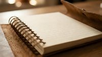 Open spiral notebook with blank pages on wooden desk surface with warm ambient lighting for writing and planning projects.