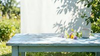 Outdoor garden table with fresh flowers, coffee cup, and morning sunlight casting leaf shadows, perfect for lifestyle, wellness, and home decor projects.