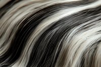 Flowing waves of black and white hair strands create abstract pattern with soft curves and natural highlights, macro photography closeup view for beauty and fashion design.