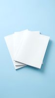 Stack of blank white paper sheets on light blue background for mockup design templates and creative projects.