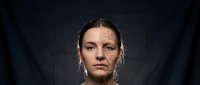 Young Caucasian woman with dramatic lighting showing half face aging effects, conceptual portrait for skincare and anti-aging treatments on dark background.