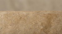 Fine golden sand dune with smooth texture against soft beige background for natural desert landscape and summer vacation concepts.