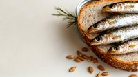 Whole fresh sardines arranged on crusty bread with rosemary and almonds, ideal for food styling, culinary blogs, restaurant menus, and healthy eating content.