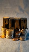 Wooden letterpress blocks spelling PLAN surrounded by stacks of golden coins on rustic surface representing financial planning and investment strategy concepts.