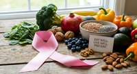 Pink ribbon with fresh organic vegetables, fruits, nuts and seeds on wooden table promoting healthy nutrition and cancer awareness lifestyle.
