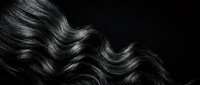 Luxurious flowing wavy hair with natural shine and movement against dark background for beauty and haircare concepts.