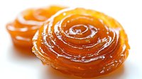 Golden amber honey swirled in elegant spiral pattern on white background, natural sweetener for culinary and wellness applications.