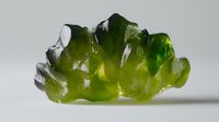 Translucent green gummy candy shaped like dinosaur on white background, macro food photography showing texture and light transmission through gelatin surface.
