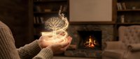 Young woman holding glowing tree of life symbol in cupped hands by cozy fireplace, representing growth, spirituality and inner peace in warm home setting.