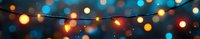 Glowing string lights against dark blue evening sky creating festive bokeh effect, magical outdoor party atmosphere for celebrations and events.