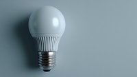 Modern LED light bulb on minimalist blue-gray background, symbolizing energy efficiency and sustainable technology for environmental concepts.