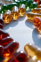 Colorful vitamin capsules and supplements scattered on white surface with soft lighting for health and wellness concepts.
