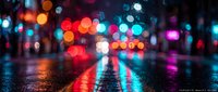 Blurred city street lights create colorful bokeh reflections on wet asphalt pavement during rainy night, abstract urban background for design projects.