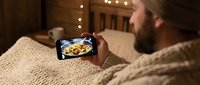 Man with beard taking food photo on smartphone, capturing meal for social media sharing and content creation.