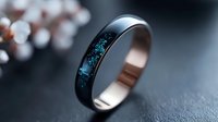 Elegant wedding band with black exterior and rose gold interior featuring inlaid blue crushed opal creating ethereal galaxy effect against dark background.
