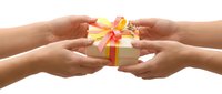 Two pairs of hands exchanging a wrapped gift box with colorful ribbon bow, isolated on white background for holiday and celebration designs.