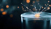 Water drop splash creating crown shape with glowing orange bokeh lights in dark blue background, macro photography capturing liquid dynamics and surface tension.