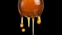 Glossy amber honey dripping from a round blob, isolated on transparent background. Ready for food packaging, stickers, t-shirt design, clipart, and print on demand projects.