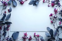 Blank white card surrounded by blue leaves and pink flowers creating natural frame on light background, perfect for wedding invitation or greeting card design.