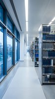 Modern university library interior with blue bookshelves and large windows creating bright study environment for academic research and learning.