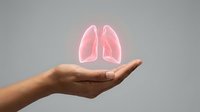 Glowing pink lungs floating above open palm against neutral background, representing respiratory health, medical care, and organ donation awareness for healthcare communications.