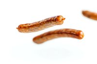 Grilled sausages with crispy brown crust isolated on pure white background, close-up view showing juicy meat texture and caramelized surface.