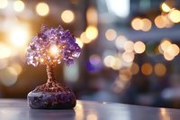 Handcrafted copper wire tree with purple crystal gemstones on natural stone base against warm bokeh background creates magical atmosphere for spiritual decor.